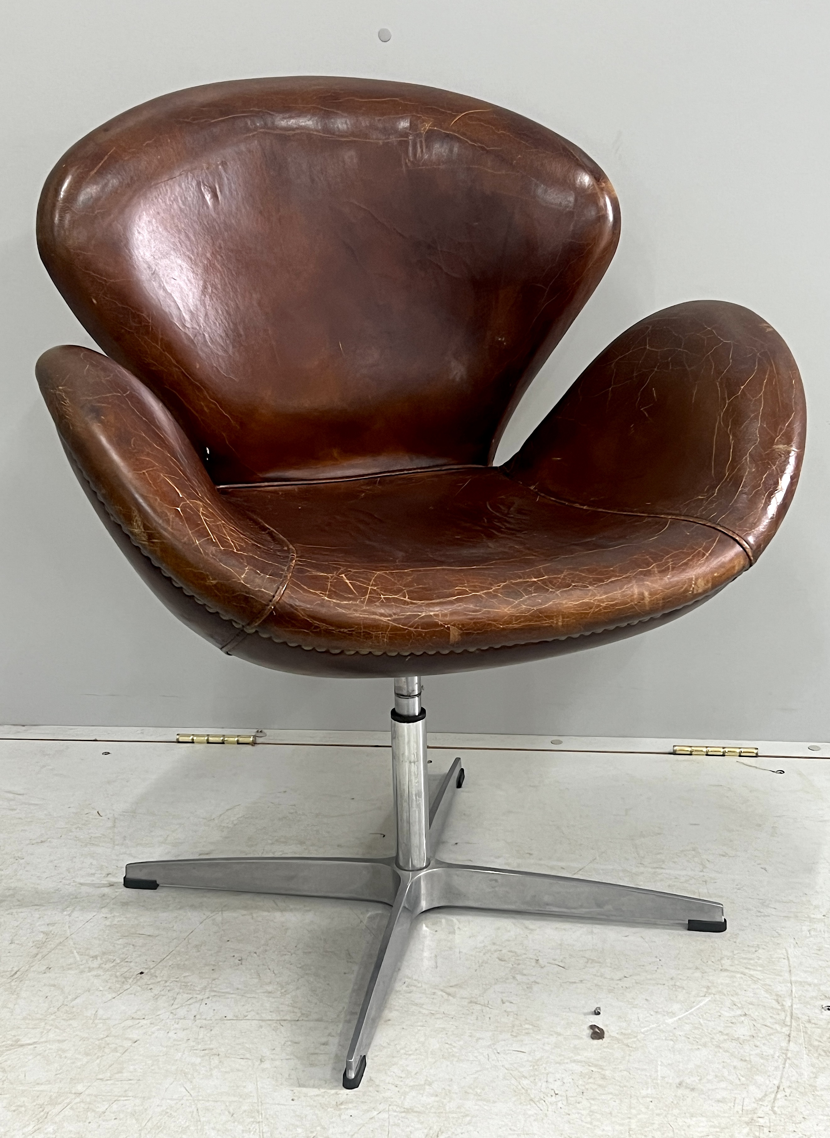 A tan leather petal chair, width 70cm, depth 42cm, height 84cm